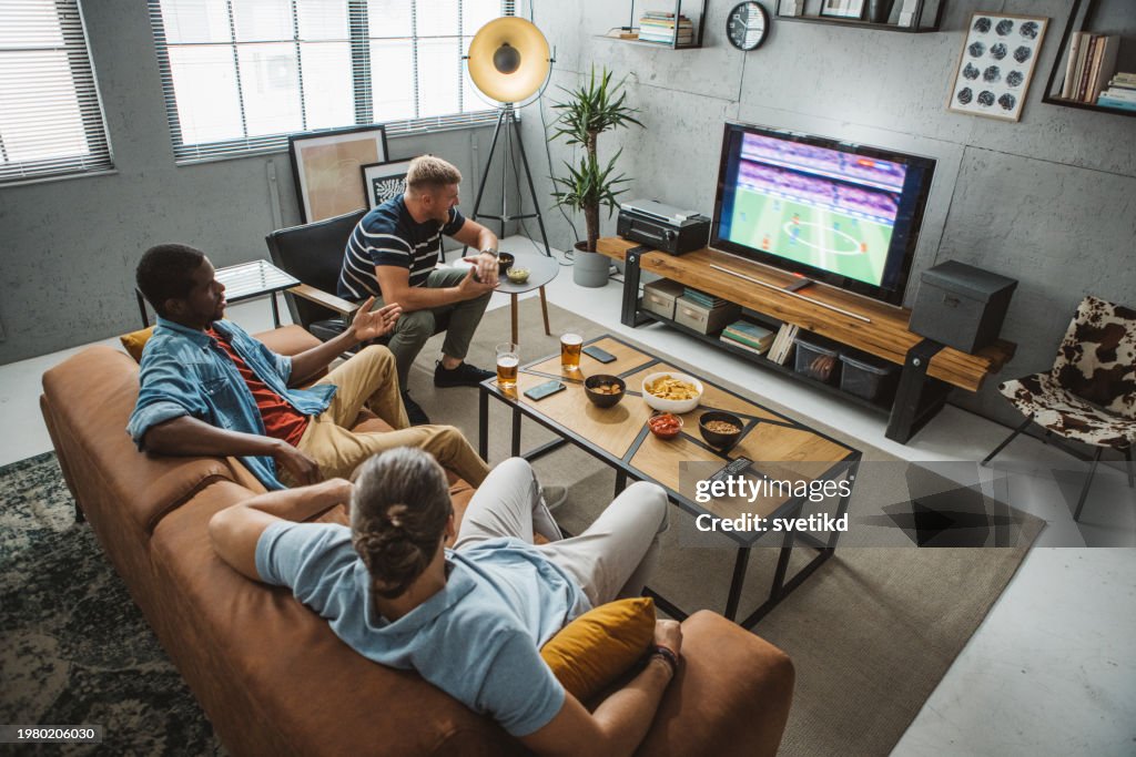 Friends watching soccer championship at home