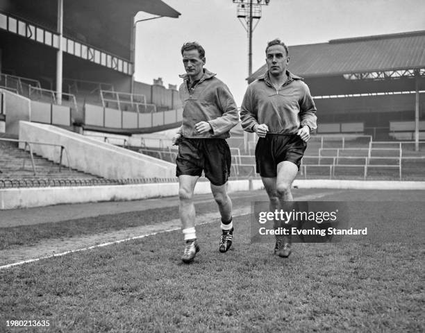 British footballer Tom Finney and running alongside British footballer Tom Finney during an England training session at Highbury Stadium in London,...