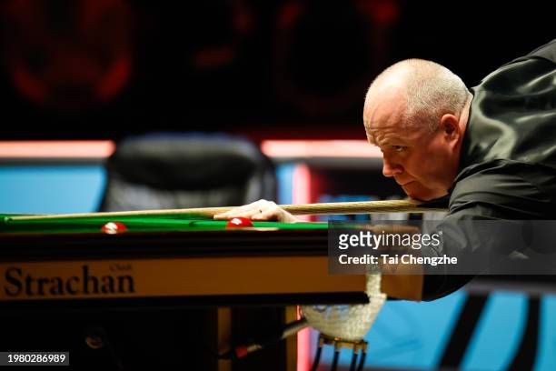 John Higgins of Scotland plays a shot in the quarter-final match against Judd Trump of England on day 5 of 2024 BetVictor German Masters at Tempodrom...