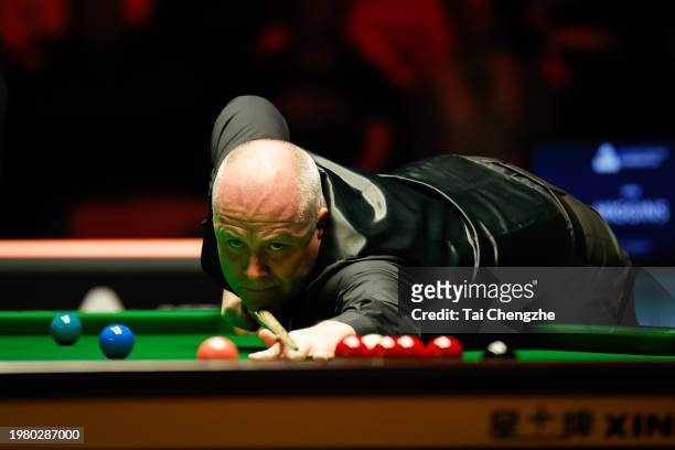 John Higgins of Scotland plays a shot in the quarter-final match against Judd Trump of England on day 5 of 2024 BetVictor German Masters at Tempodrom...