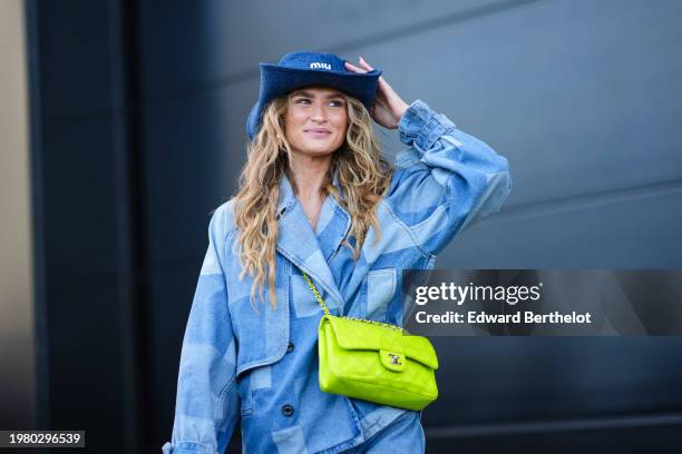 Guest wears a blue cowboy hat from Miu Miu, a blue patchwork denim jacket , a neon yellow Chanel bag, outside Munthe, during the Copenhagen Fashion...