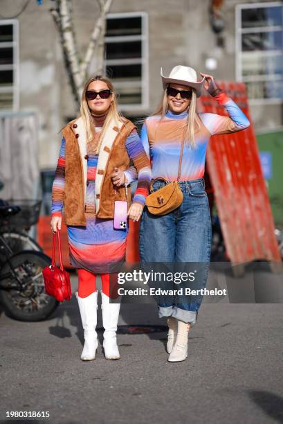 Guest wears sunglasses, a brown sleeveless suede jacket , a colored striped turtleneck midi dress, red leggings, white boots ; a guest wears a white...