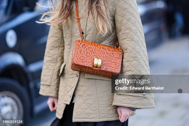 Guest wears beige / khaki padded oversized jacket , a brown crocodile pattern leather bag, outside Munthe, during the Copenhagen Fashion Week AW24 on...