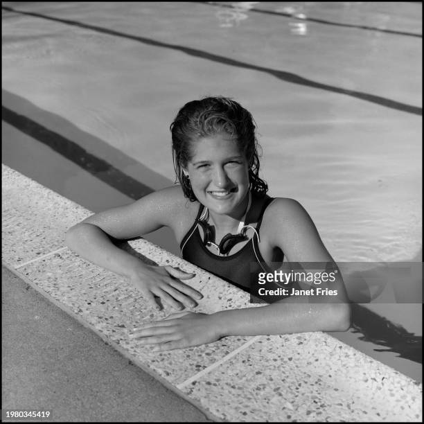 Portrait of American collegiate swimmer Kelley Davies as she poses in the water, at the side of a swimming pool, June 28, 1987.