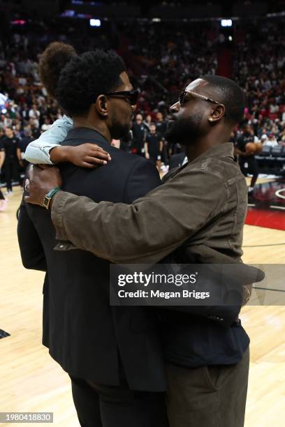 Former Miami Heat players Udonis Haslem and Dwayne Wade speak on the court during halftime of a game between the Atlanta Hawks and Miami Heat at...