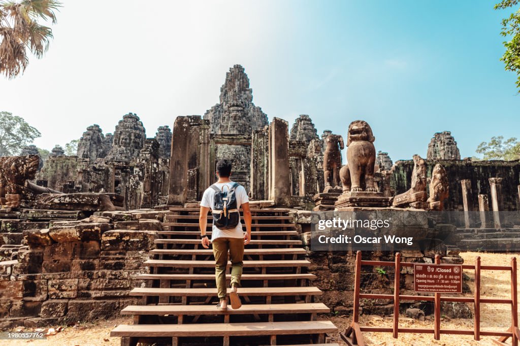 Rear view of young Asian man entering Bayon Temple in Angkor Thom, Siem Reap, Cambodia