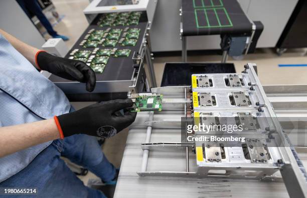 An employee places individual Raspberry Pi personal computers on to the final packaging line at the Sony UK Technology Centre in Pencoed, UK, on...