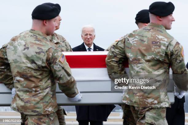 President Joe Biden places his hand over his heart while watching a U.S. Army carry team move a flagged draped transfer case containing the remains...