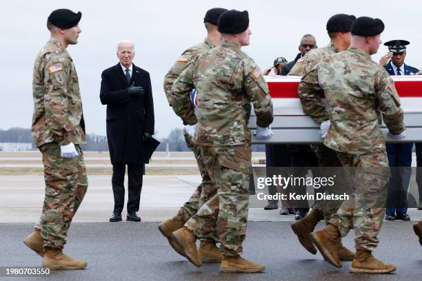 President Joe Biden places his hand over his heart while watching a U.S. Army carry team move a flagged draped transfer case containing the remains...
