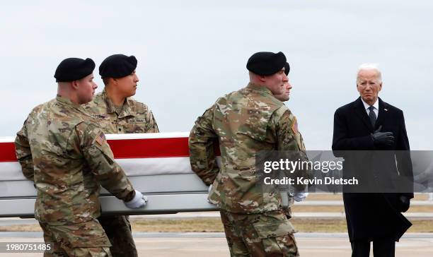 President Joe Biden places his hand over his heart as a U.S. Army carry team moves a flagged draped transfer case containing the remains of Army Sgt....