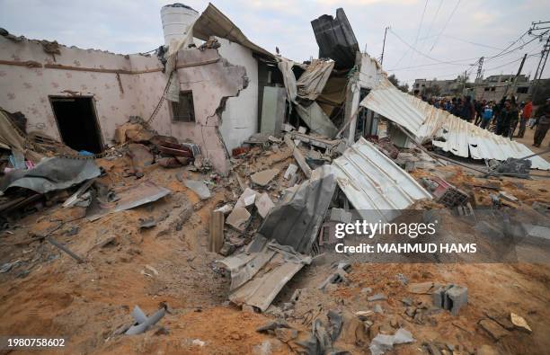 People gather around the Abu Saleh family home in Rafah in the southern Gaza Strip on February 5 after it was hit during Israeli bombardment, amid...