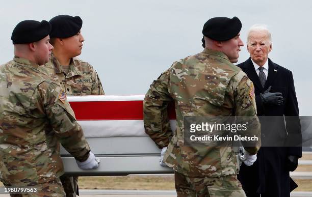 President Joe Biden places his hand over his hear as a U.S. Army carry team moves a flagged draped transfer case containing the remains of Army Sgt....
