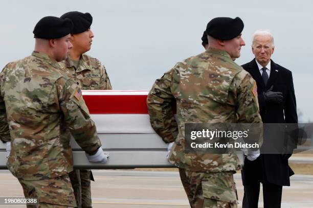 President Joe Biden places his hand over his heart as a U.S. Army carry team moves a flagged draped transfer case containing the remains of Army Sgt....