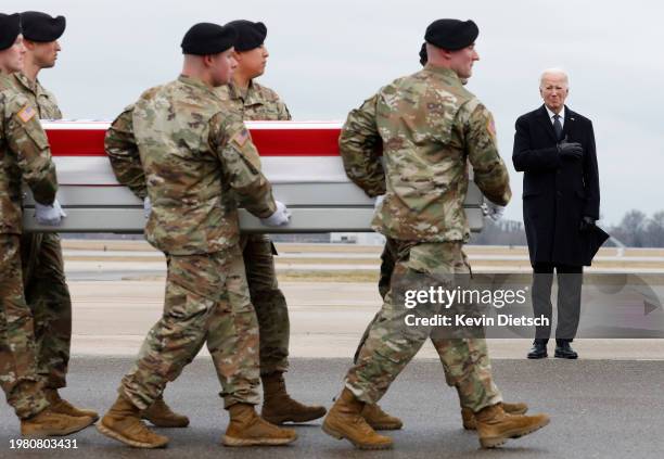 President Joe Biden places his hand over his heart as a U.S. Army carry team moves a flagged draped transfer case containing the remains of Army Sgt....