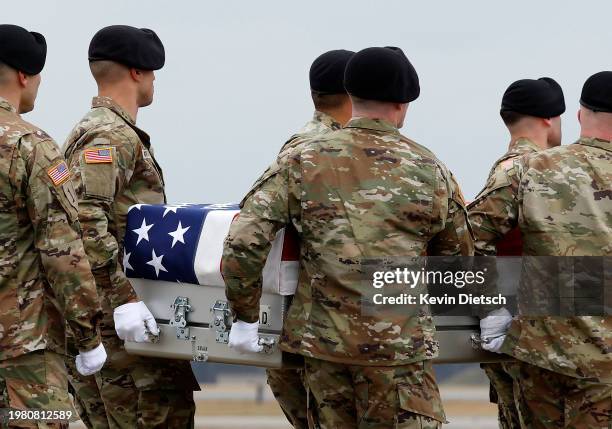 Army carry team moves the flagged draped transfer case containing the remains of Army Sgt. William Rivers during a dignified transfer at Dover Air...