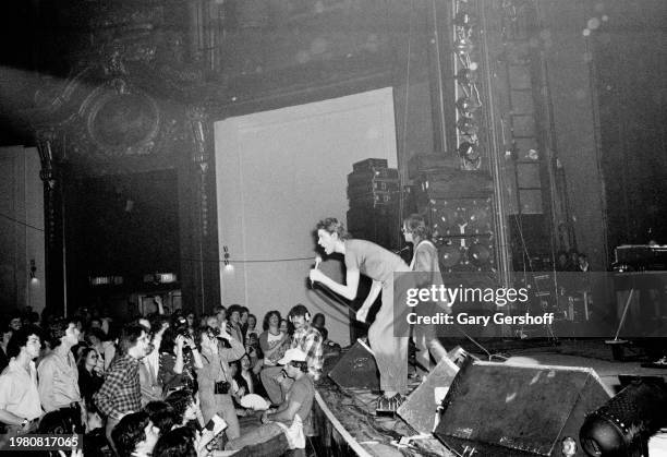 Irish New Wave singer Bob Geldof and, behind him, Gerry Cott, on guitar, both of the band the Boomtown Rats, perform onstage at the Palladium, New...