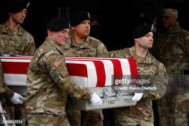 Army carry team moves the flagged draped transfer case containing the remains of Army Sgt. William Rivers during a dignified transfer at Dover Air...