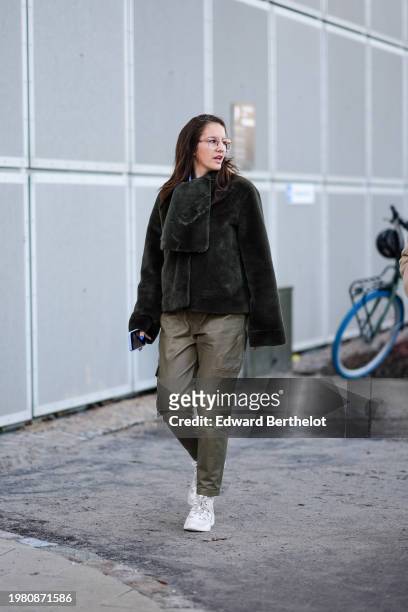 Guest wears glasses, a green fluffy jacket with flared sleeves, Heart Evangelista leather cargo pants , gray sneakers shoes , outside TG Botanical,...