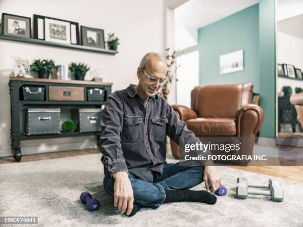 senior man having a salad meal while using laptop in his living room - daily life in toronto stock pictures, royalty-free photos & images