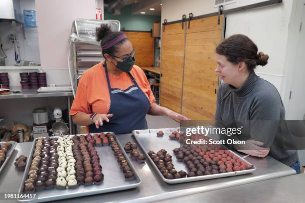 Katherine Hall and owner Katherine Duncan prepare chocolate truffles for customers at Katherine Anne Confections, an artisanal chocolate shop and...