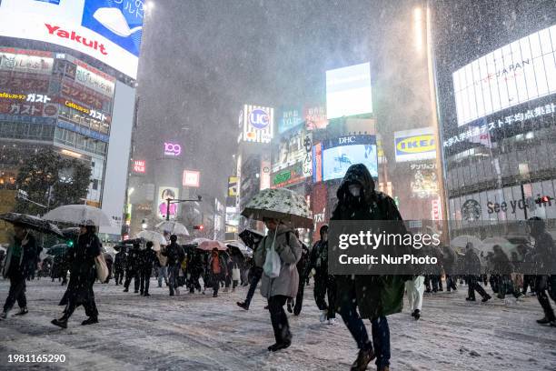 People are walking through the intersection at Shibuya in heavy snow in Tokyo, Japan, on February 5.