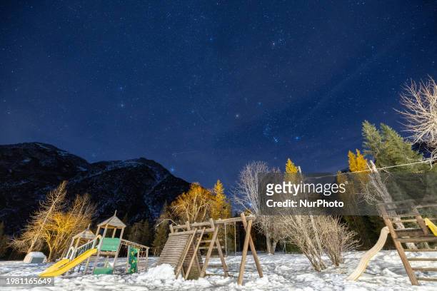 View of the starry sky above a playground covered with snow in Carbonin, Italy, on February 5, 2024.