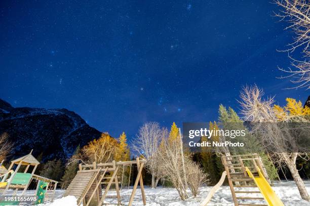 View of the starry sky above a playground covered with snow in Carbonin, Italy, on February 5, 2024.