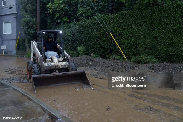 Worker moves mud and rocks from a mudslide during a storm in Los Angeles, California, US, on Monday, Feb. 5, 2024. Los Angeles and the wealthy...