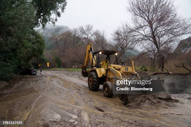 Worker moves mud on a roadway during a storm in Malibu, California, US, on Monday, Feb. 5, 2024. Los Angeles and the wealthy enclaves of Montecito...