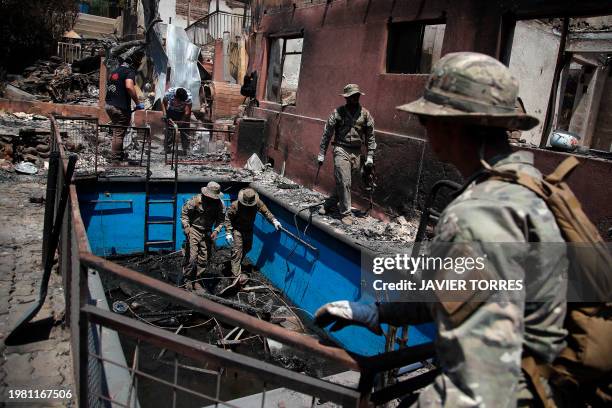 Members of the Chilean Navy help on the cleaning of burnt houses in Villa Independencia, Valparaiso region, Chile on February 5, 2024. The death toll...