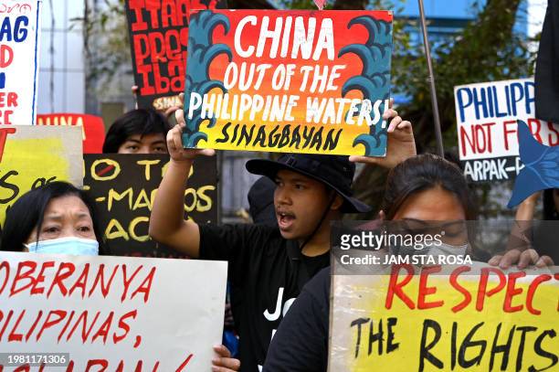 Protesters raise their placards as they stage a demonstration to condemn China's aggression in the disputed South China Sea, in front of the Chinese...