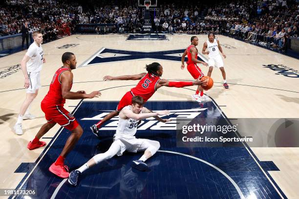 St. John's Red Storm guard Daniss Jenkins fights for a loose ball against Xavier Musketeers forward Gytis Nemeiksa during a college basketball game...