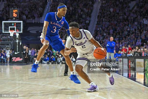 Tylor Perry of the Kansas State Wildcats dribbles the ball against Dajuan Harris Jr. #3 of the Kansas Jayhawks in the second half at Bramlage...