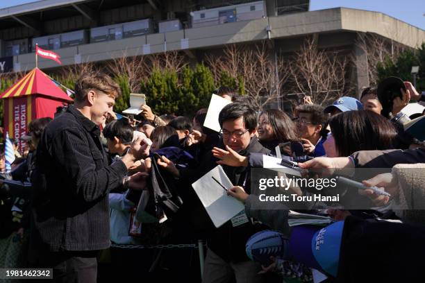 Beauden Barrett of Toyota Verblitz signs autographs for fans prior to the preseason match between Tokyo Suntory Sungoliath and Blues at Prince...