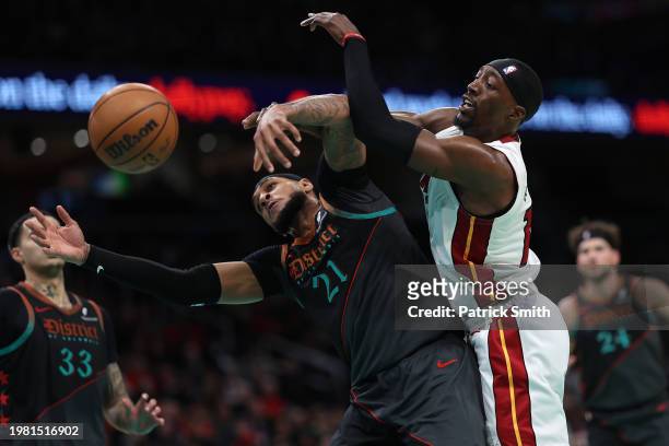 Daniel Gafford of the Washington Wizards and Bam Adebayo of the Miami Heat battle for a rebound during the second half at Capital One Arena on...