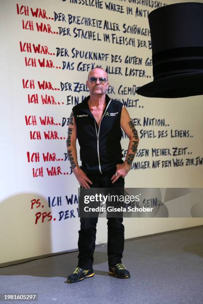 Artist Wolfgang Flatz poses in front of his hat sculpture and poem "Ich war" prior his exhibition "Something wrong with physical sculpture" at...