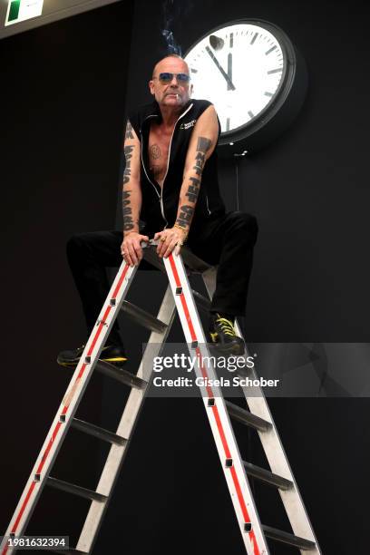 Artist Wolfgang Flatz poses in front of his "Hundert Millionen Jahre - ein Augenblick" watch with a meteorite prior the exhibition "Something wrong...