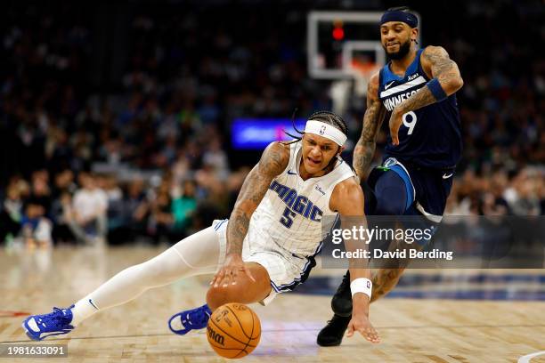 Paolo Banchero of the Orlando Magic falls as he drives to the basket against Nickeil Alexander-Walker of the Minnesota Timberwolves in the third...