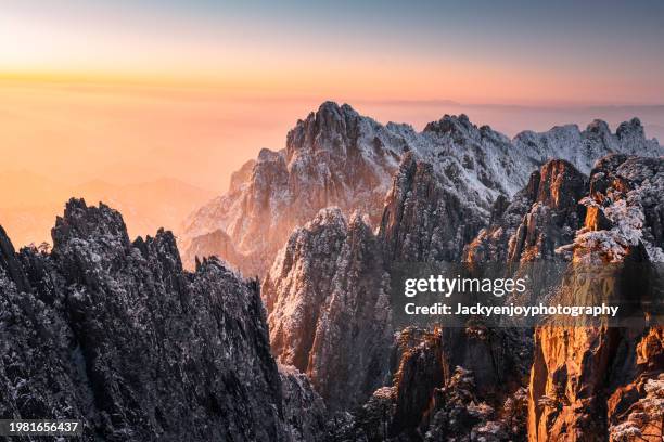 the huangshan mountain range at sunset. huangshan scenic area, anhui province, china: the observation platform and the cliffs below are illuminated by the evening sun. - huangshan mountain range anhui province china stock pictures, royalty-free photos & images