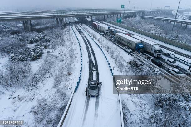 Cars are stuck on a highway due to heavy snow in Wuhan, in central China's Hubei province on February 6, 2024. / China OUT