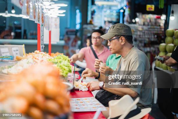 asian traveler buy thai style halal barbecue stick food from street vendor - halal stock pictures, royalty-free photos & images