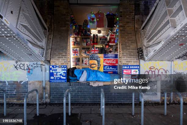 Homeless person sleeping rough in a sleeping bag outside a tourism souvenir shop underneath Blackfriars Bridge on 16th January 2024 in London, United...