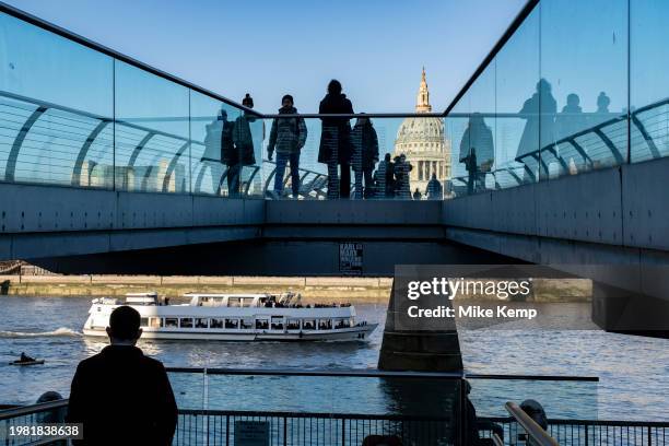 View of tourists and local people crossing the Millennium Bridge with St Paul's Cathedral rising in the background on 16th January 2024 in London,...