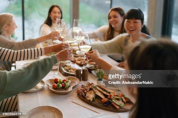 friends enjoying a dinner party - ホームパーティ　日本人 ストックフォトと画像