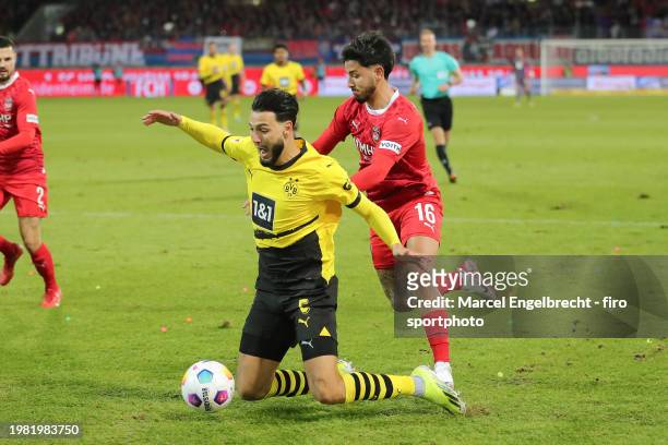 Ramy Bensebaini of Borussia Dortmund and Kevin Sessa of 1. FC Heidenheim 1846 compete for the ball during the Bundesliga match between 1. FC...