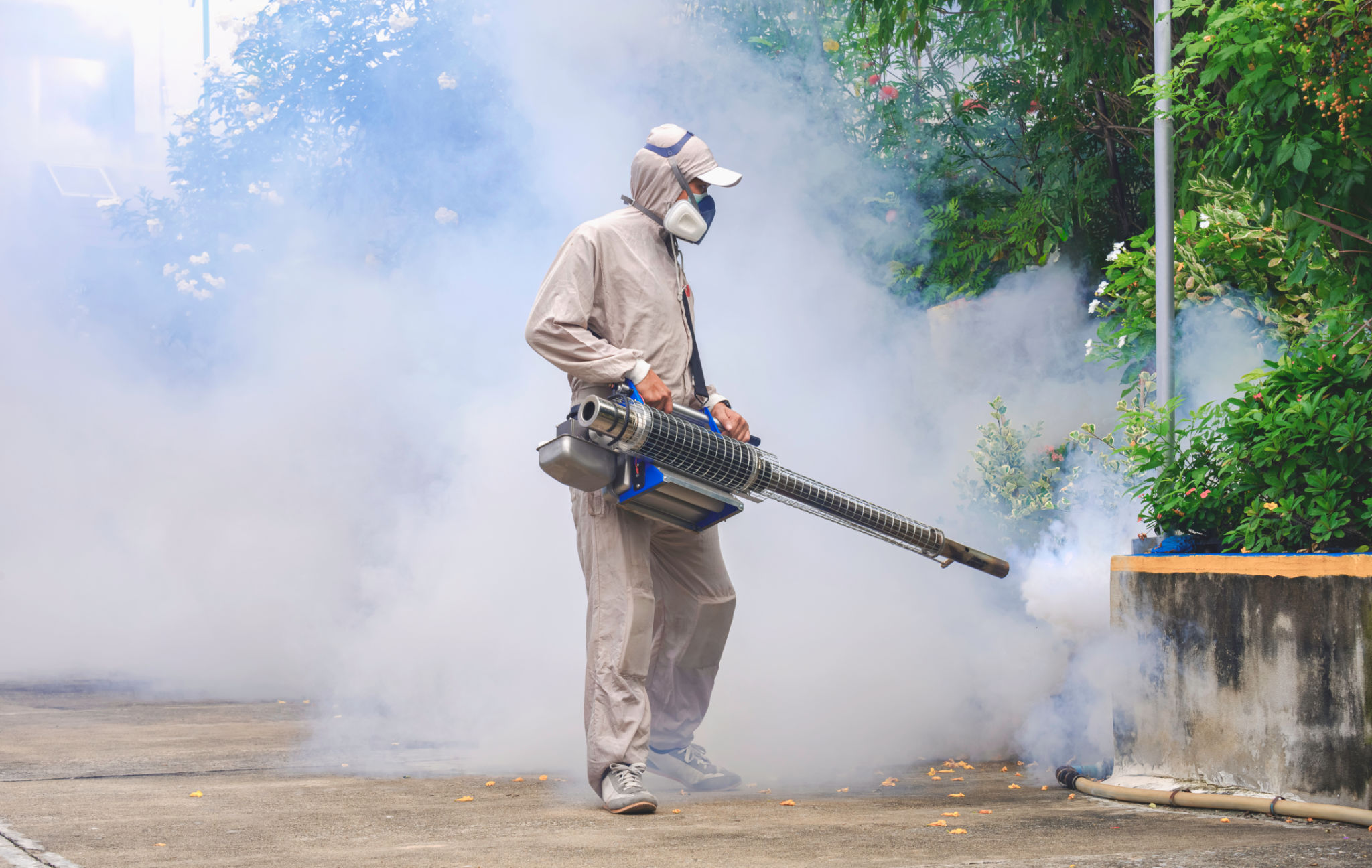 Profissional de saúde ao ar livre pulverizando produtos químicos para eliminar mosquitos em área coberta de vegetação em local geral em área pública Profissional de saúde ao ar livre pulverizando produtos químicos para eliminar mosquitos em área coberta de vegetação em local geral em área pública