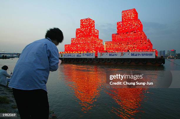 South Korean buddhist prays in front of floating lanterns in honor of the Buddha's birthday on the Han River May 8, 2003 in Seoul, South Korea....