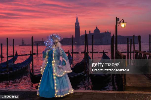 Masked masked reveller poses for a sunrise portrait in St. Mark's Square during Venice Carnival 2024 on February 03, 2024 in Venice, Italy. The...