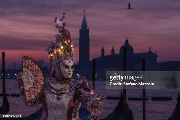 Masked masked reveller poses for a sunrise portrait in St. Mark's Square during Venice Carnival 2024 on February 03, 2024 in Venice, Italy. The...