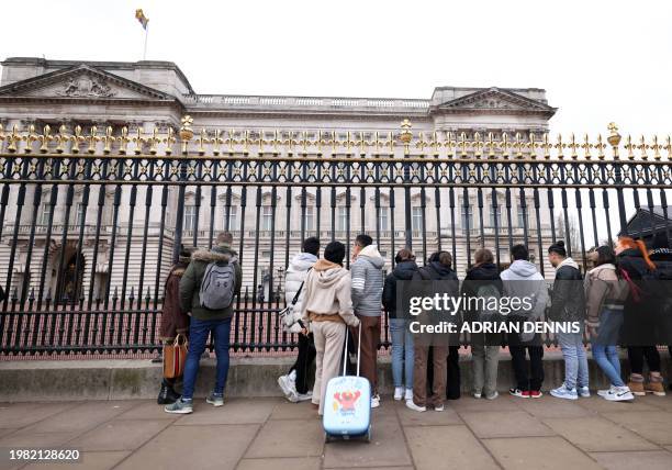 Tourists gather outside the gates of Buckingham Palace in London on February 6, 2024. King Charles III has been diagnosed with cancer and has begun...